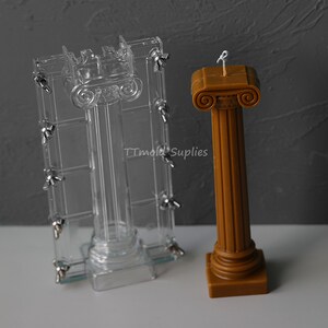 Puede incluir: Un molde de pl&aacute;stico transparente para hacer una vela pilar, con una vela pilar marr&oacute;n hecha con el molde al lado. La vela tiene una parte superior decorativa con un dise&ntilde;o de rollo.