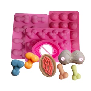 May include: Pink silicone moulds for making various shapes of chocolate or candy. The moulds include a variety of shapes, including hearts, eyes, and other abstract shapes.