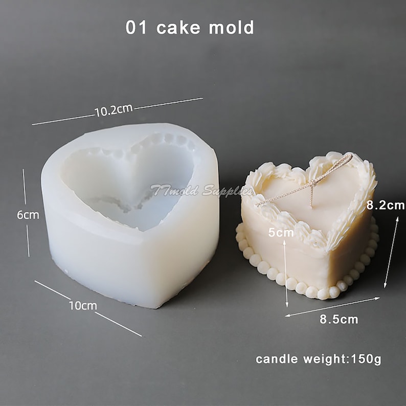 Puede incluir: Un molde para pastel de silicona blanco en forma de coraz&oacute;n con medidas en cent&iacute;metros. El molde est&aacute; al lado de una vela terminada en forma de coraz&oacute;n con glaseado blanco y una cuerda atada alrededor. La vela mide 8,2 cm de alto, 8,5 cm de ancho y 5 cm de profundidad. La vela pesa 150 gramos.