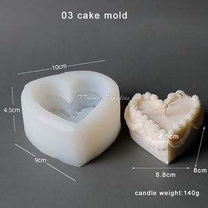 Puede incluir: Molde para pastel de silicona blanco en forma de coraz&oacute;n con medidas en cent&iacute;metros. El molde mide 10 cm de ancho, 9 cm de alto y 4,5 cm de profundidad. Se muestra una vela blanca en forma de coraz&oacute;n junto al molde, con medidas de 8 cm de ancho, 8,8 cm de alto y 4,5 cm de profundidad. La vela pesa 140 gramos.