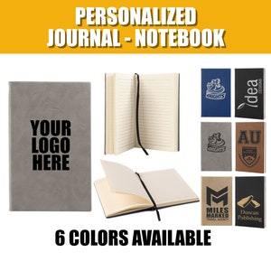 May include: Six personalized journals in different colors, including gray, blue, brown, and black. The journals have different logos printed on the front, including "Knights", "idea", "AU", "Miles Marked Travel Agency", and "Duncan Publishing". The text "YOUR LOGO HERE" is printed on the gray journal. The text "6 COLORS AVAILABLE" is printed below the journals.