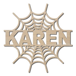 May include: A wooden cutout of a spiderweb with the name "KAREN" in the center. The cutout is designed for crafting and personalization.