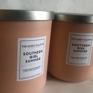 May include: Two pink candles with silver lids. The labels read "The Scent Palette" and "Southern Girl Summer". The candles are artisanal coconut soy blend candles made in New Orleans, LA.