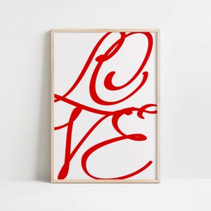 Könnte beinhalten: Ein gerahmter Druck mit dem stilisierten Wort "LOVE" in Rot auf weißem Hintergrund.
