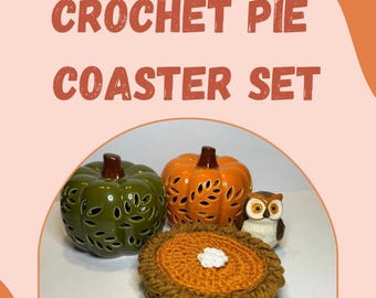 May include: A crochet pie coaster set with a pumpkin theme. The set includes a crochet pie coaster, two ceramic pumpkins, and a small owl figurine. The pumpkins are green and orange, and the owl is brown and white. The text "CROCHET PIE COASTER SET" is at the top.