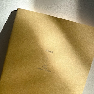 May include: A gold notebook with the word "Notes" printed on the front. The notebook is blank, 100gsm, and has 30 sheets or 60 pages.