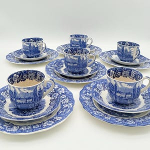 Könnte beinhalten: Ein Set aus blau-weißem Porzellan mit Teetassen, Untertassen und Tellern. Die Teetassen und Teller weisen ein detailliertes Landschaftsdesign auf. Das Set enthält mehrere Tassen, Untertassen und Teller, ideal zum Servieren von Tee.