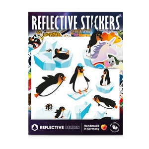 May include: A sheet of reflective stickers featuring various penguin designs. The stickers are on a white background with a blue and white ice-themed design. The text "Reflective Stickers" is at the top of the sheet. The text "Reflective Berlin" and "Handmade in Germany" is at the bottom of the sheet.
