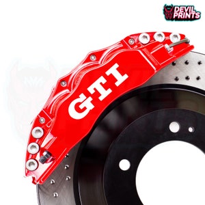 May include: Red brake caliper with a white "GTI" decal. The caliper is attached to a silver brake rotor.