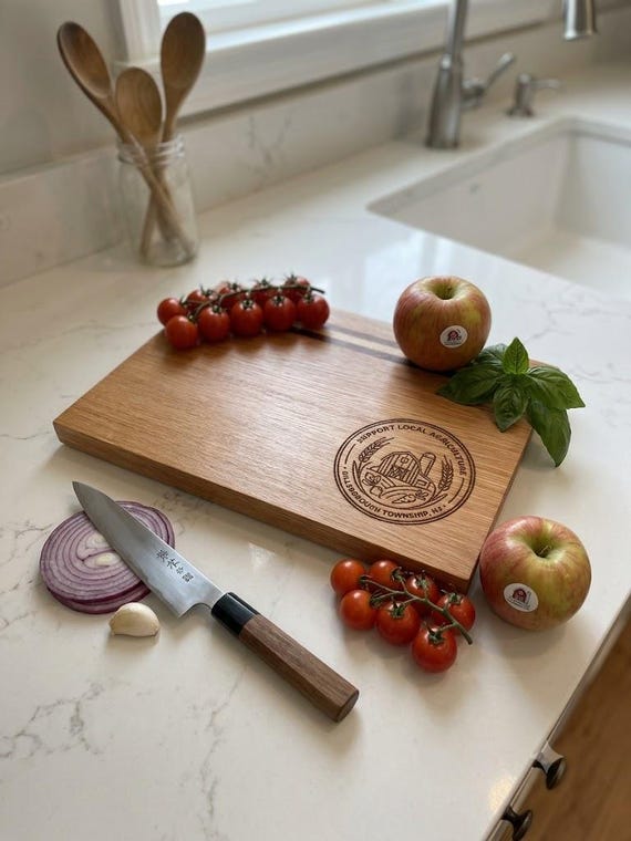 A cutting board laser-engraved with your city's actual local agriculture emblem — hyper-local personalization that makes a housewarming gift feel genuinely thoughtful.