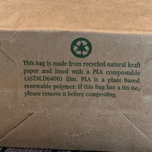 May include: A brown paper bag with a green recycling symbol and text that reads: "This bag is made from recycled natural kraft paper and lined with a PLA compostable (ASTM D6400) film. PLA is a plant based renewable polymer. If this bag has a tin tie, please remove it before composting."
