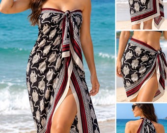 May include: A black sarong featuring a repeating white tiger pattern with a decorative border in red, white, and black. The fabric is tied at the front, creating a wrap-style silhouette that can be worn as a dress, skirt, or shawl.