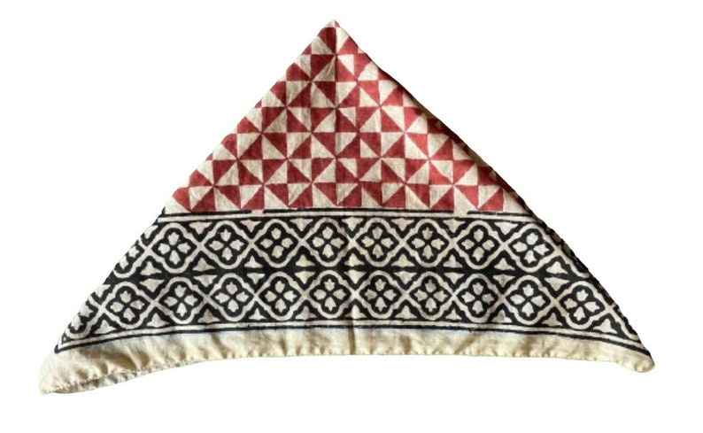 K&ouml;nnte beinhalten: Ein dreieckiges Baumwollbandana mit einem roten und wei&szlig;en geometrischen Muster auf der oberen H&auml;lfte und einem schwarzen und wei&szlig;en geometrischen Muster auf der unteren H&auml;lfte.