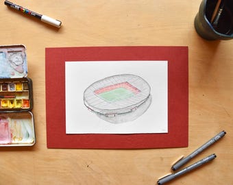 May include: A black and white drawing of a stadium with a green field and red seats. The drawing is on a white piece of paper with a red border.