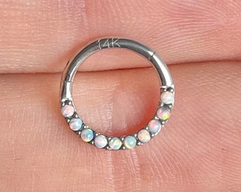 May include: A silver hoop earring with a row of opal gemstones. The earring is marked "14K" on the hoop.