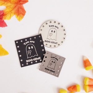 May include: Three different sizes of black and gray leather patches with a ghost and the text "You are BOO-tiful!"  The patches are decorated with white polka dots.