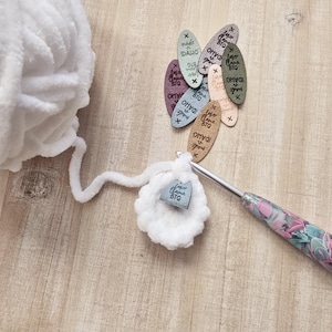 May include: White yarn with a crochet hook and a small blue tag that says "Love You Big" on it. There are also several small leather tags with the text "Made in Idaho" and "Love You Big" on them.