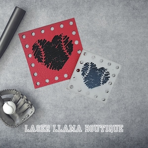 Peut inclure: Deux découpes en bois en forme de cœur rouge et blanc avec un motif de points de baseball. Le texte "LASER LLAMA BOUTIQUE" est imprimé sous les découpes.