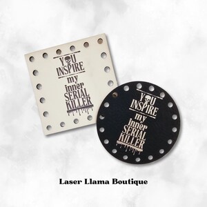 May include: Two laser-cut wooden tags with the text "You inspire my inner serial killer" and a skull graphic. The tags are in different shapes, one square and one round. The square tag is white and the round tag is black.