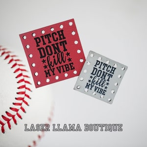 Peut inclure: Deux patchs carrés avec le texte "Pitch Don't Kill My Vibe" en lettres noires sur fond rouge et blanc. Les patchs ont des trous autour des bords.