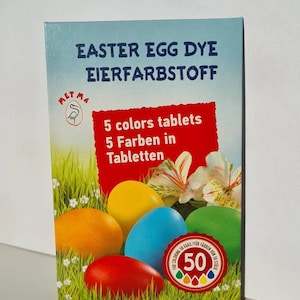 Pode incluir: Uma caixa de corante para ovos de Páscoa em comprimidos com um logotipo de pássaro vermelho, branco e azul. A caixa mostra cinco ovos coloridos e o texto "EASTER EGG DYE EIERFARBSTOFF 5 colors tablets 5 Farben in Tabletten". A caixa também tem um adesivo que diz "FOR COLORING 50 EGGS/FUR FARBEN 50 STÜCK" com um número 50 e cinco gotas coloridas.
