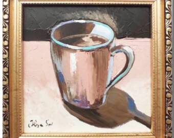 May include: A painting of a mug of coffee on a pink surface. The mug is light pink with a blue rim and a brown handle. The painting is framed in a gold frame.