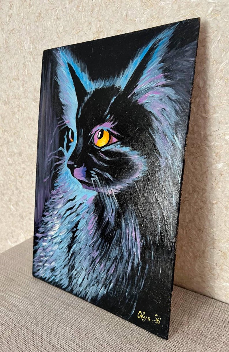 May include: A painting of a black cat with bright yellow eyes, set against a dark background. The cat's fur is painted with shades of blue and purple, creating a vibrant and abstract effect. The artist's signature, "Olya", is visible in the bottom right corner.