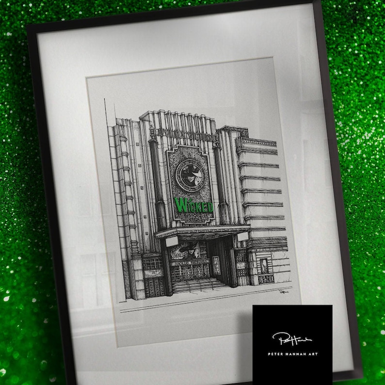 Puede incluir: Un dibujo en blanco y negro del teatro Wicked en la ciudad de Nueva York. El dibujo est&aacute; enmarcado en un marco negro con un passe-partout blanco. El teatro se representa con un gran letrero que dice "Wicked" en letras verdes.