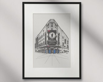 May include: A black and white line drawing of the Cambridge Theatre in London, England. The theatre is showing the musical "Matilda" with a poster featuring a young girl with a book. The drawing is framed in a black frame.