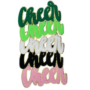 May include: A stack of embroidered patches in the word "Cheer" in a cursive font. The patches are in green, lime green, white, black, and pink, each with gold glitter trim. Cheerleading apparel.