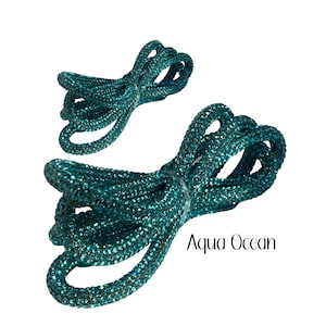 May include: Aqua Ocean rhinestone trim, a teal blue, sparkly, decorative trim for crafts and embellishments.