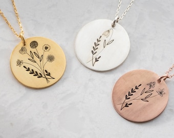 Op de afbeelding: Drie delicate kettingen met ronde hangers met een bloemenmotief. De hangers zijn van goud, zilver en rosé goud.