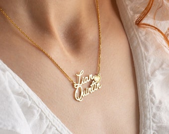 May include: A gold necklace with two names, "Lian" and "Quentin", spelled out in cursive script. A small heart charm hangs between the names.