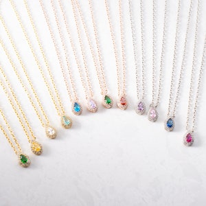 May include: A set of ten delicate necklaces with teardrop-shaped pendants featuring various coloured gemstones surrounded by clear cubic zirconia stones. The necklaces are available in gold, rose gold, and silver.