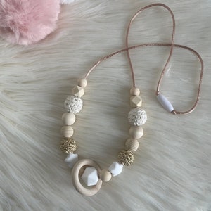 Collar de lactancia o portabebé en color beige, blanco, dorado y con forma de estrella