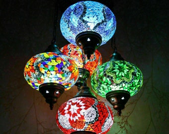 May include: A multi-colored mosaic glass chandelier with five round pendant lights. The lights are in shades of blue, green, red, and yellow.