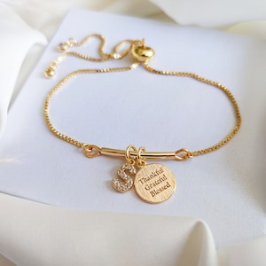 May include: Gold adjustable bracelet with a charm that says "Thankful Grateful Blessed" and a letter "S" charm with rhinestones.