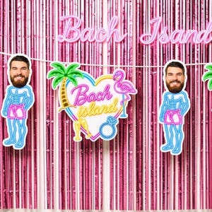 Puede incluir: Una guirnalda de fiesta con recortes de un hombre con barba, palmeras, flamencos y corazones con el texto Bach Island, colgada sobre una cortina de flecos rosa metálico. La guirnalda incluye gráficos repetidos de copas de champán y anillos.