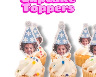 May include: A set of cupcake toppers featuring a photo of a child wearing a blue party hat with a white snowflake pattern. The text Cupcake Toppers is displayed in large pink letters above the cupcakes, which are topped with white frosting and colorful sprinkles.