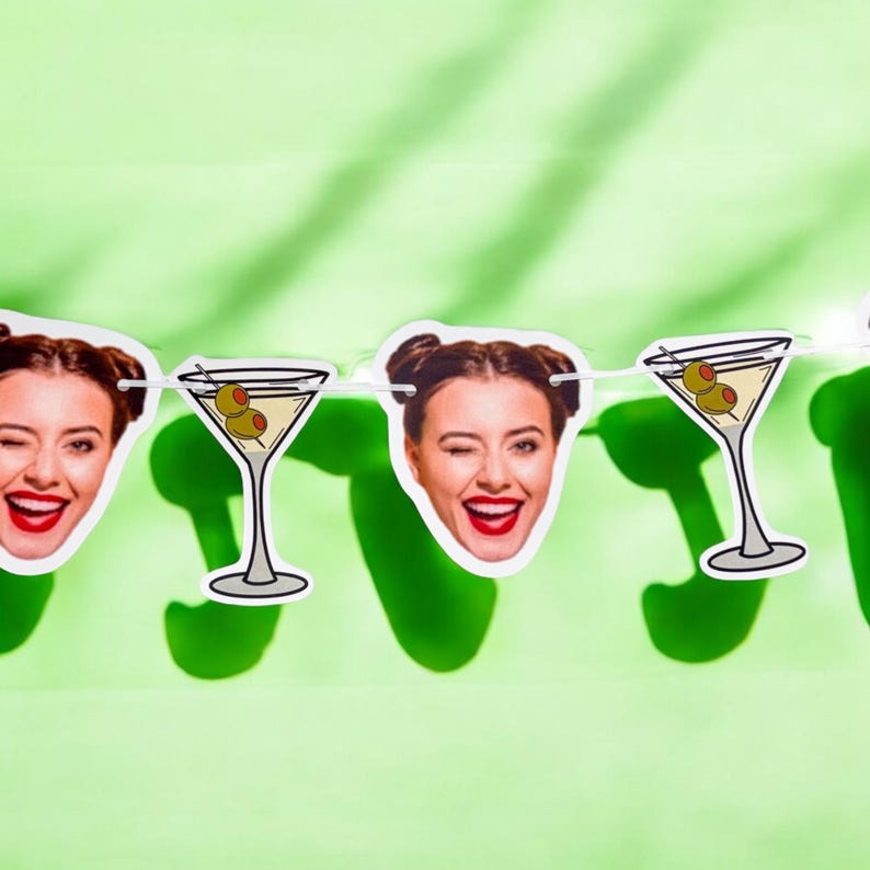 K&ouml;nnte beinhalten: Eine gr&uuml;ne und wei&szlig;e Girlande aus Partydekorationen mit abwechselnden Bildern eines Martini-Glases mit Oliven und einem Frauenkopf. Die Frau zwinkert und tr&auml;gt roten Lippenstift.