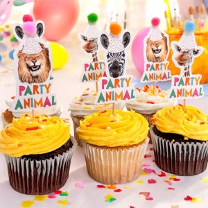 Puede incluir: Seis cupcakes decorados con glaseado amarillo y chispas de colores. Cada cupcake tiene una decoraci&oacute;n tem&aacute;tica de animales de fiesta con dise&ntilde;os de le&oacute;n, cebra, jirafa y otros animales. Las decoraciones tienen el texto "Party Animal".