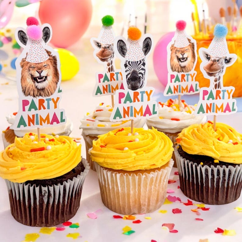 Puede incluir: Seis cupcakes decorados con glaseado amarillo y chispas de colores. Cada cupcake tiene una decoraci&oacute;n tem&aacute;tica de animales de fiesta con dise&ntilde;os de le&oacute;n, cebra, jirafa y otros animales. Las decoraciones tienen el texto "Party Animal".