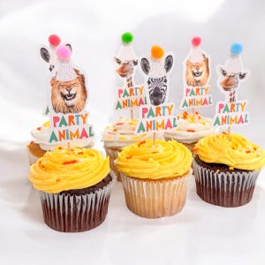 Puede incluir: Seis cupcakes decorados con glaseado amarillo y chispas de colores. Cada cupcake tiene una decoraci&oacute;n tem&aacute;tica de animales de fiesta con un le&oacute;n, una cebra, una jirafa y un sombrero de fiesta colorido. Las decoraciones tienen el texto "Party Animal".