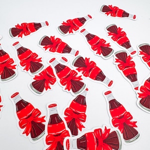 Puede incluir: Una colecci&oacute;n de pegatinas con un dise&ntilde;o de botella de refresco marr&oacute;n oscuro con un lazo rojo. La botella tiene una tapa roja y una etiqueta blanca. Las pegatinas est&aacute;n dispersas sobre un fondo blanco.