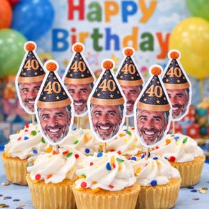 May include: Cupcakes with white frosting and colorful sprinkles, topped with face cutouts wearing party hats that read "40". The background includes balloons and a banner that says "Happy Birthday".