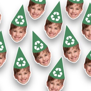 May include: A set of green party hats with a white recycling symbol on the front. Each hat features a different child's face.