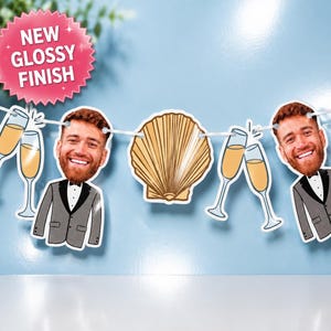 Puede incluir: Una guirnalda decorativa con dos recortes idénticos de una persona sonriente con barba y esmoquin gris, intercalados con ilustraciones de copas de champán y una concha marina dorada. Una etiqueta rosa en forma de estrella dice NEW GLOSSY FINISH.