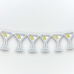 May include: A white paper banner with a repeating pattern of martini glasses with green olives. The banner is perfect for a party or celebration.