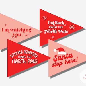 Puede incluir: Cuatro banderines triangulares rojos y rosas con texto blanco. Los banderines dicen "Te estoy vigilando", "Entrega especial del Polo Norte", "He vuelto del Polo Norte" y "¡Papá Noel para aquí!"