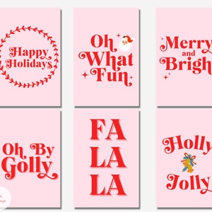 May include: Six printable Christmas cards with pink backgrounds and red text. The cards feature the phrases "Happy Holidays", "Oh What Fun", "Merry and Bright", "Oh By Golly", "Fa La La", and "Holly Jolly".